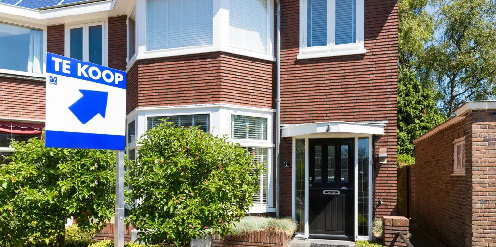 Koopwoning met Te Koop-bord bij een scheiding